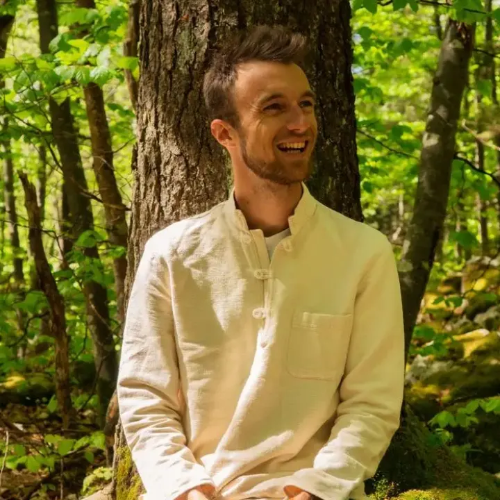 Julien, assis en tailleur dans la forêt du Vercors