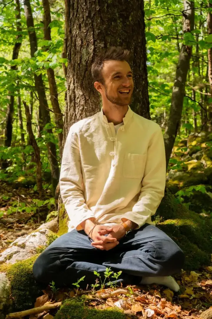 Julien, assis en tailleur dans la forêt du Vercors