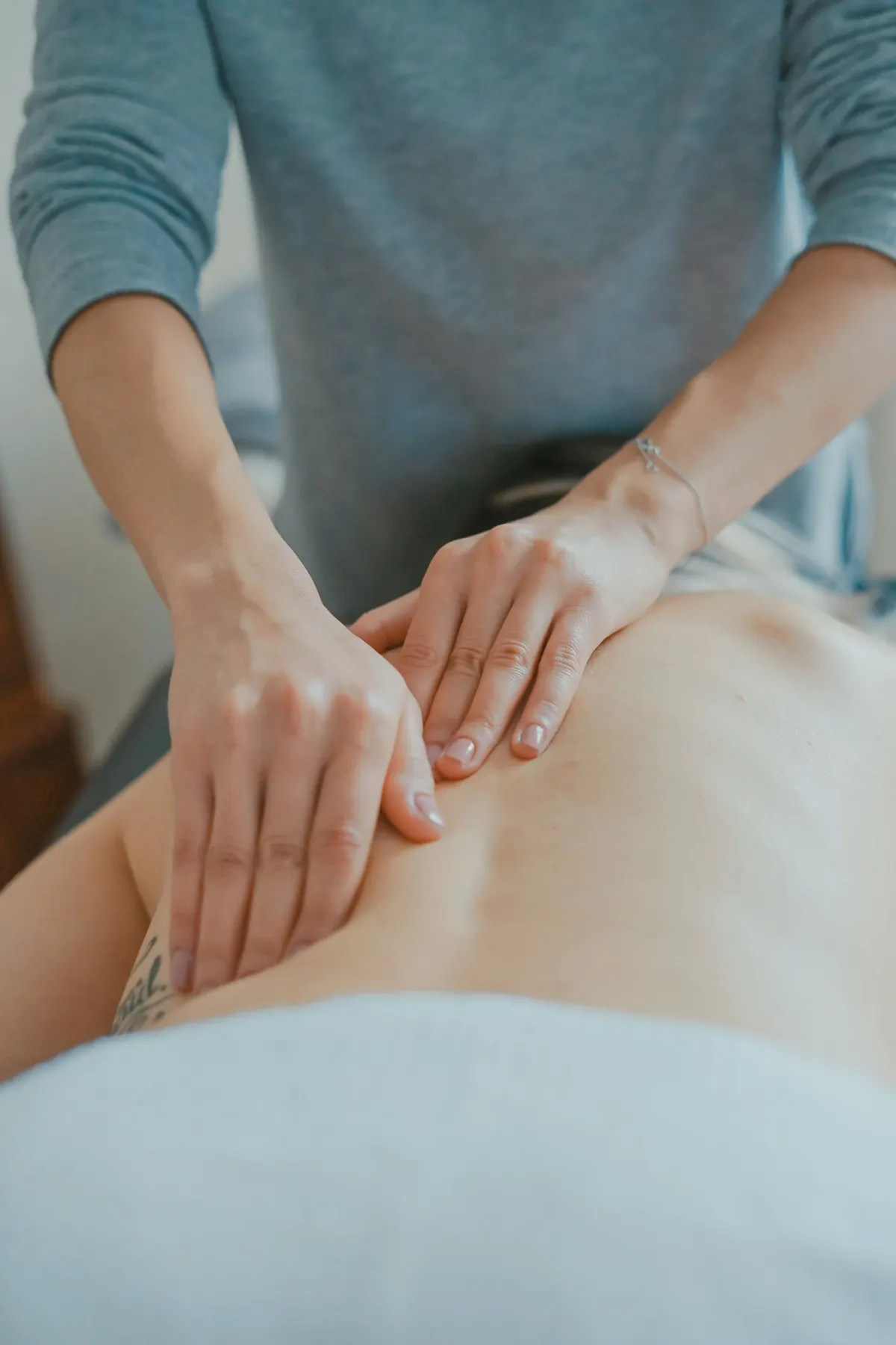 Des mains de praticienne pendant un massage bien-être