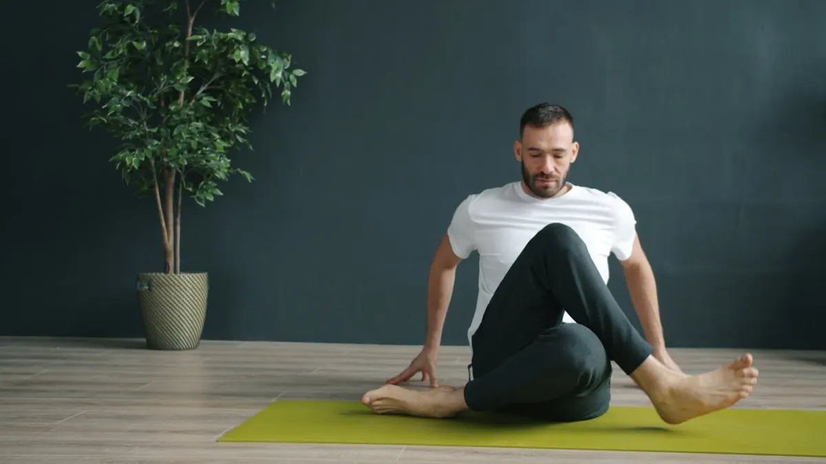 Un prof de yoga en posture assise dans un studio lumineux