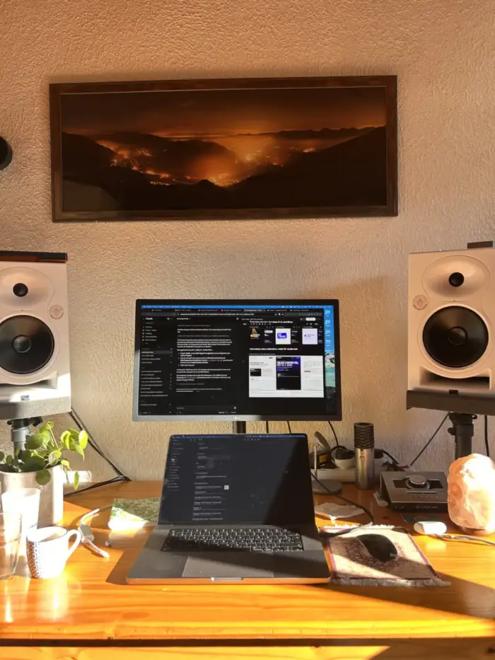 Le bureau de Julien dans le Vercors : écran, ordinateur portable et enceintes de studio